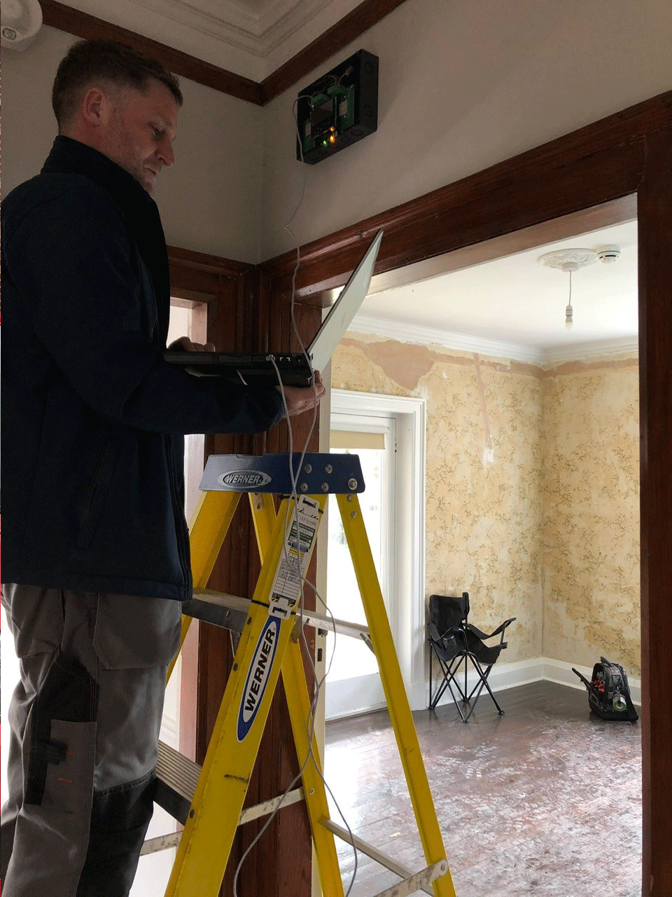 Firequeen technician installing wireless fire alarm